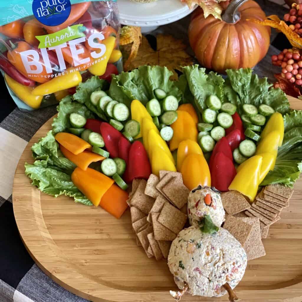 A turkey cheeseball grazing board with vegetables and crackers.