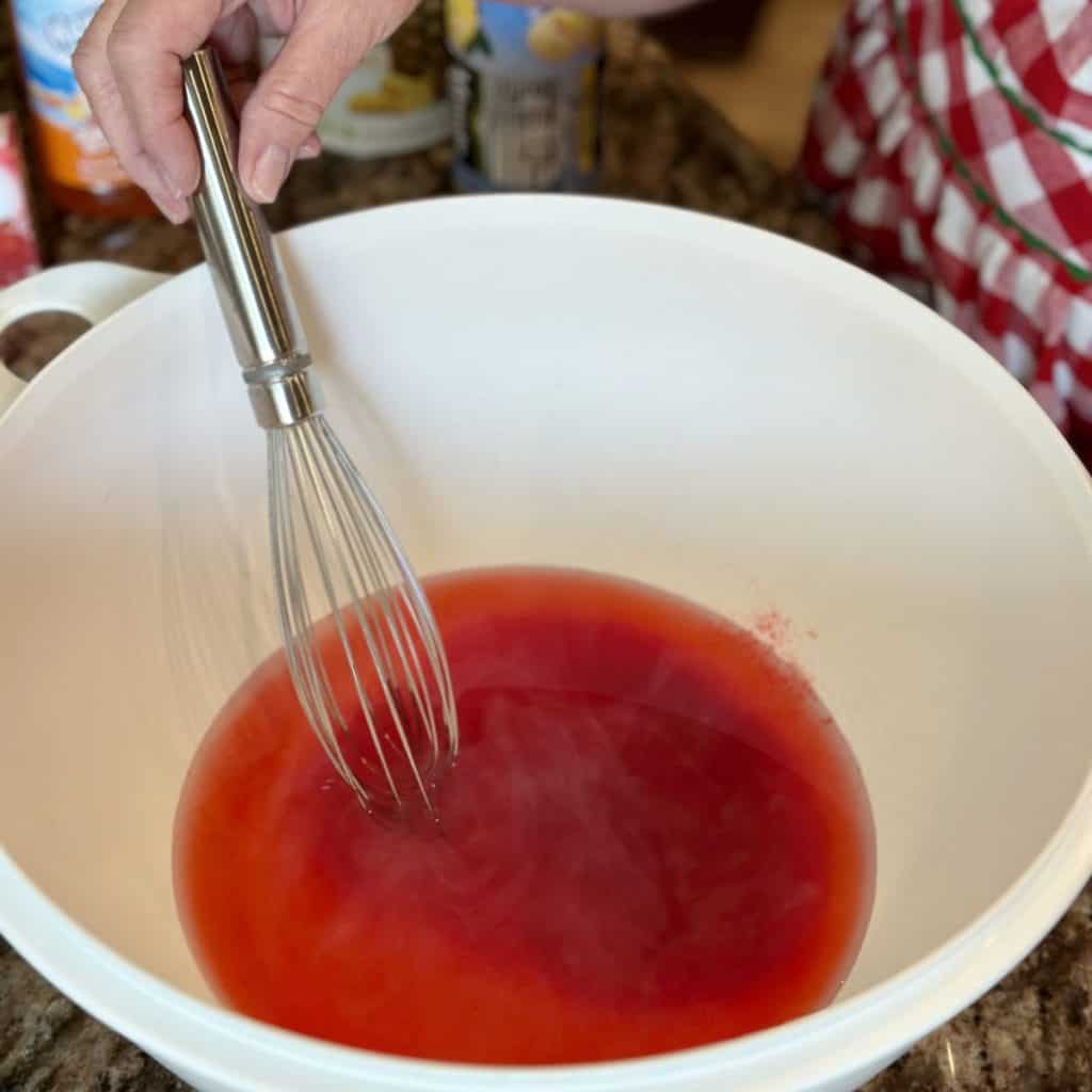 Whisking together jello, sugar and water.