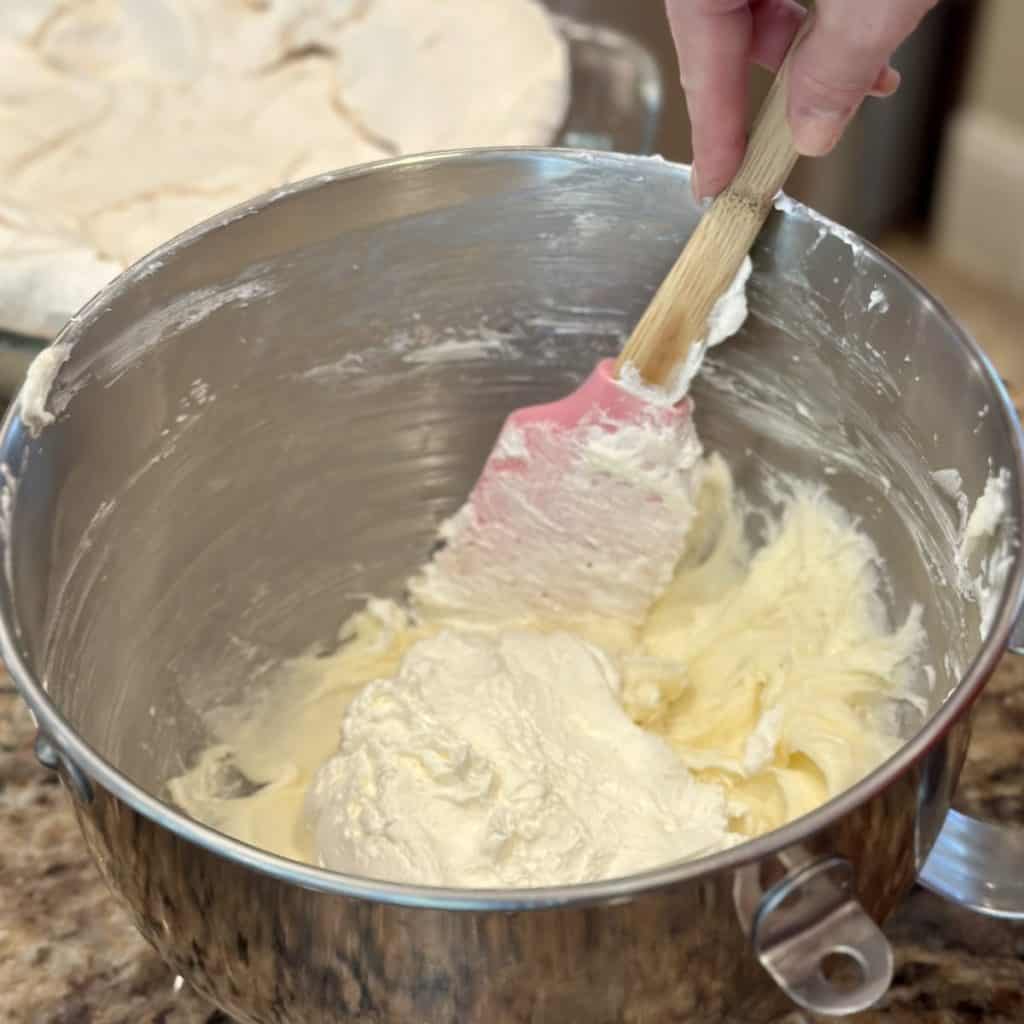 Folding whipped cream in a cream cheese mixture. 