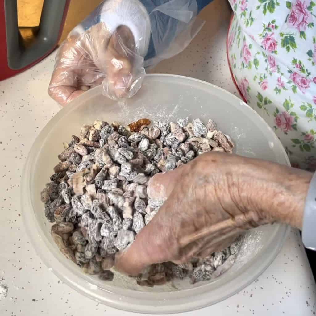 Coating raisins and pecans with flour.