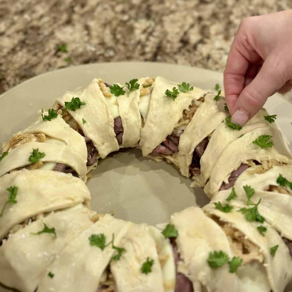 Adding parsley to crescent dough.