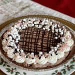 This is a picture of a festive chocolate pie decorated with whipped cream and crushed peppermint candy.