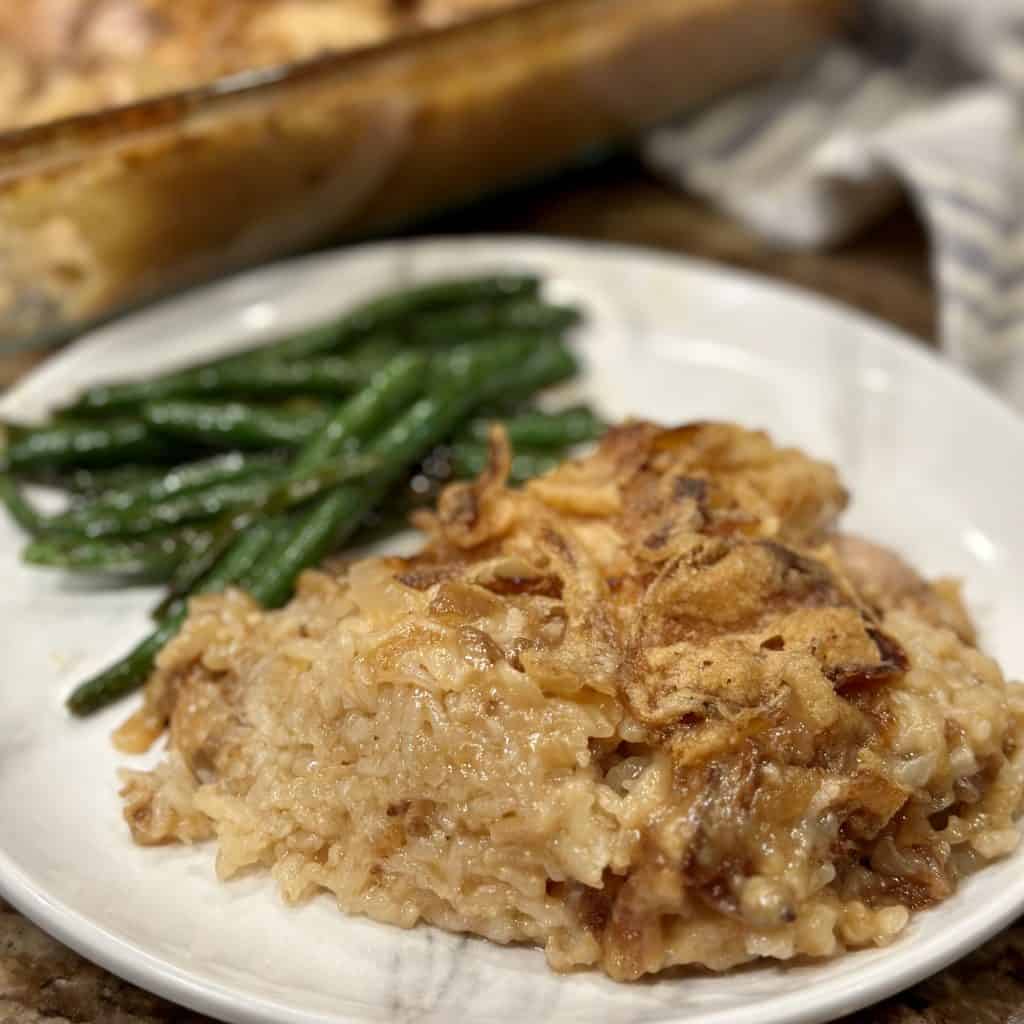 French onion chicken and rice served with green beans on a dinner plate