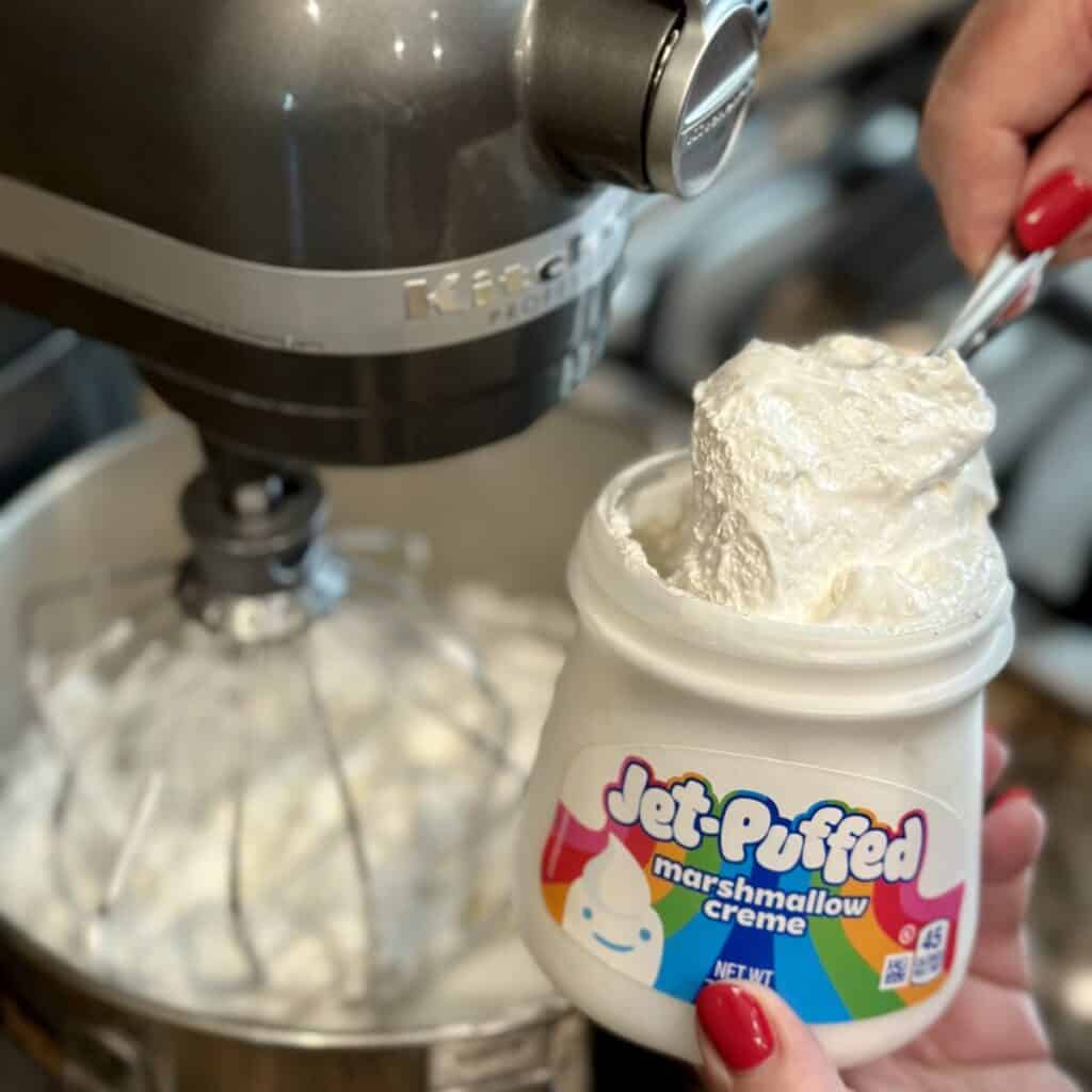 Adding marshmallow cream to a stand mixer.
