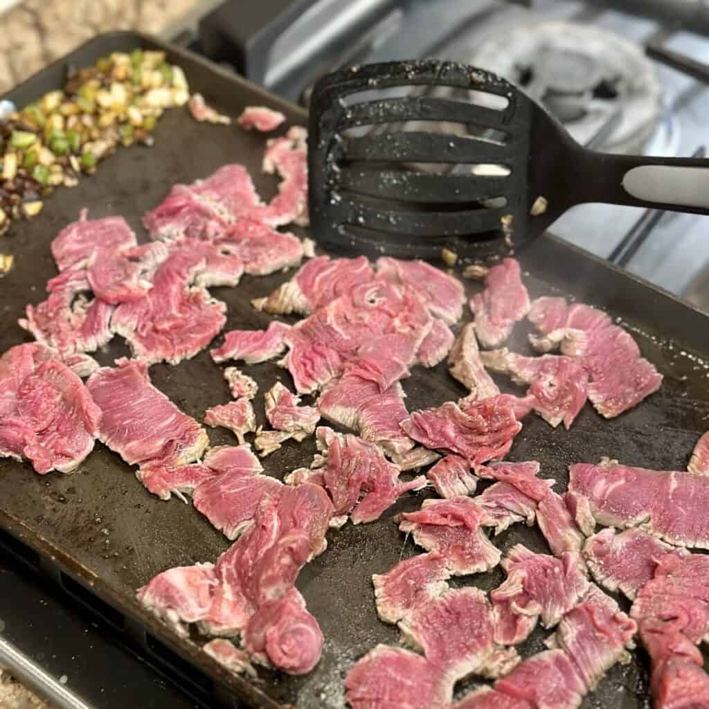 Searing steak on a griddle.