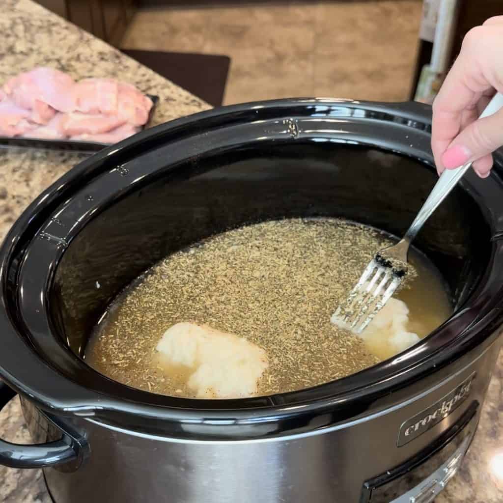 whisking together ingredients in a crockpot