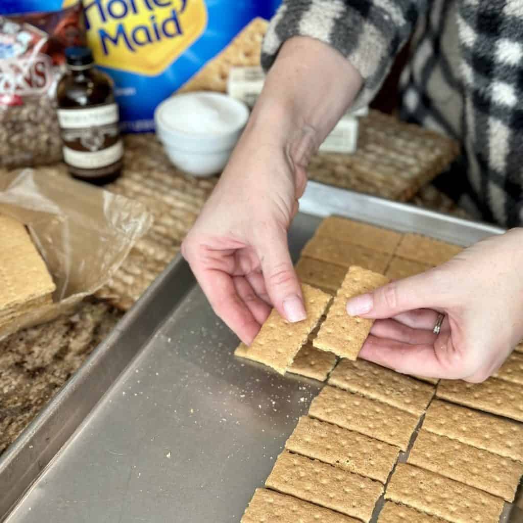 Breaking apart graham crackers on a sheet pan.
