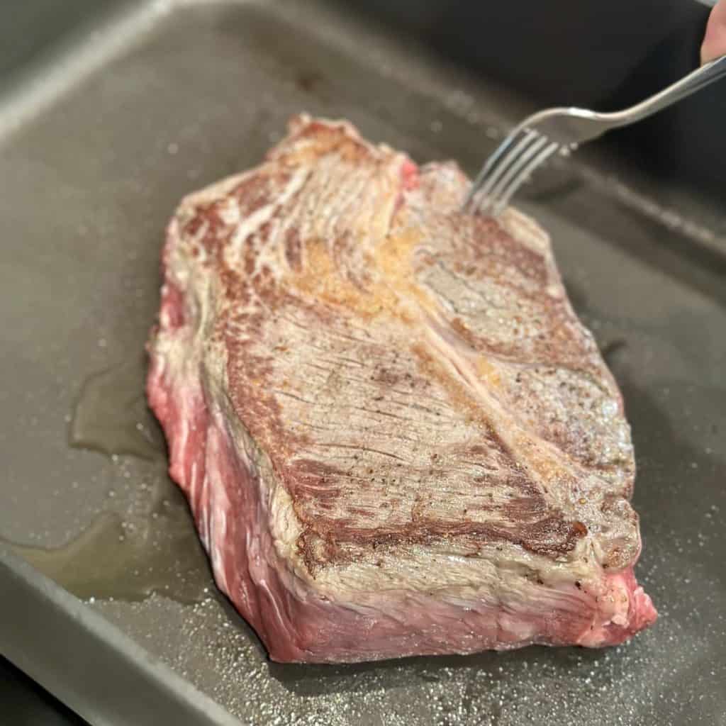 Searing a roast in a skillet.