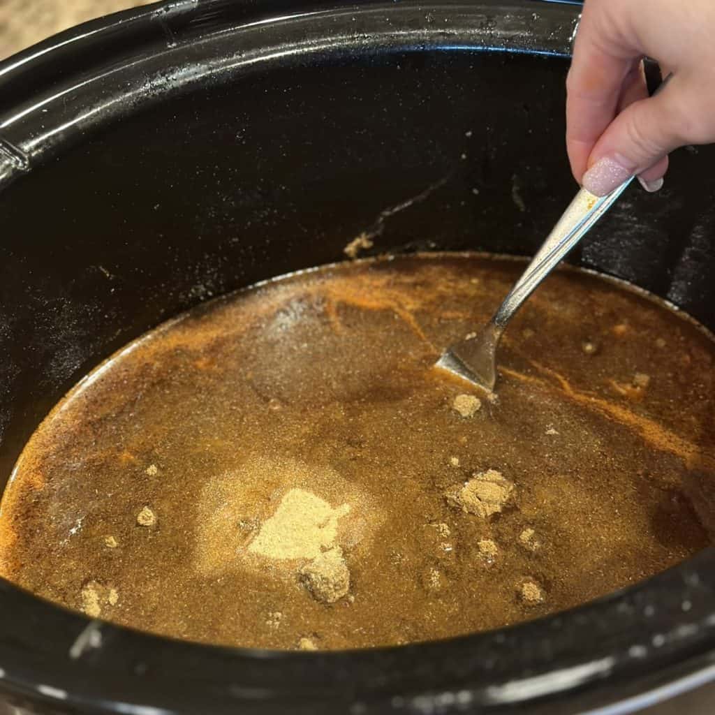Mixing together a enchilada sauce in a crockpot.
