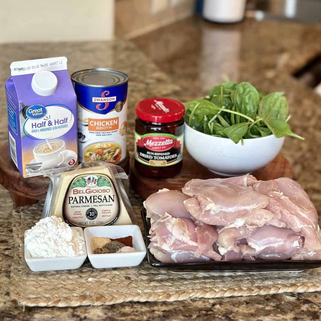 The ingredients to make creamy crockpot Tuscan chicken.