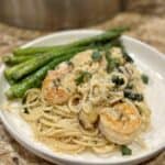 A plate of crab and shrimp scampi and asparagus.