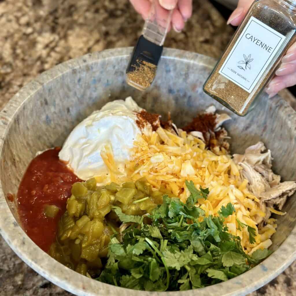 Adding the ingredients to the filling for Mexican lasagna.