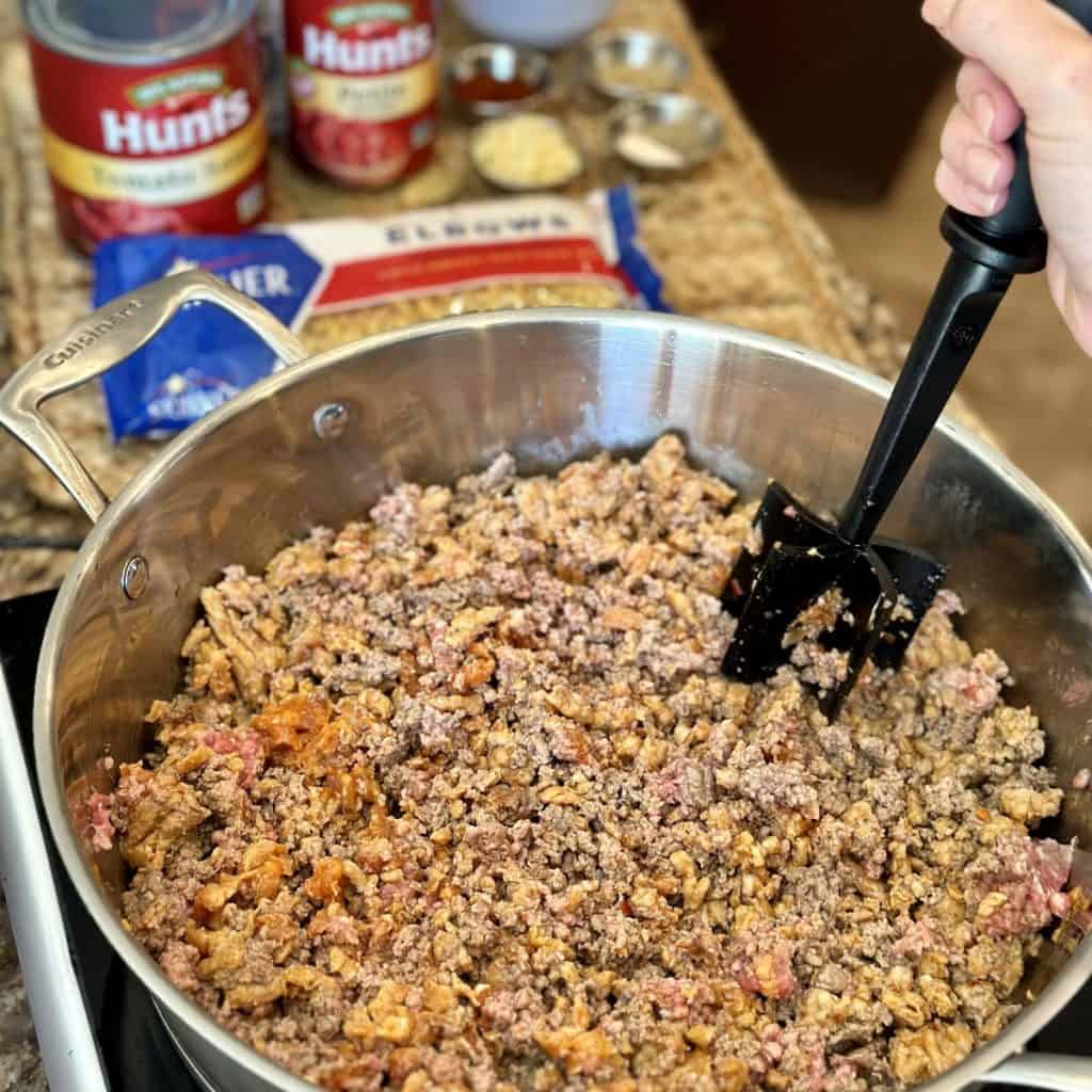 Browning sausage and hamburger in a skillet.