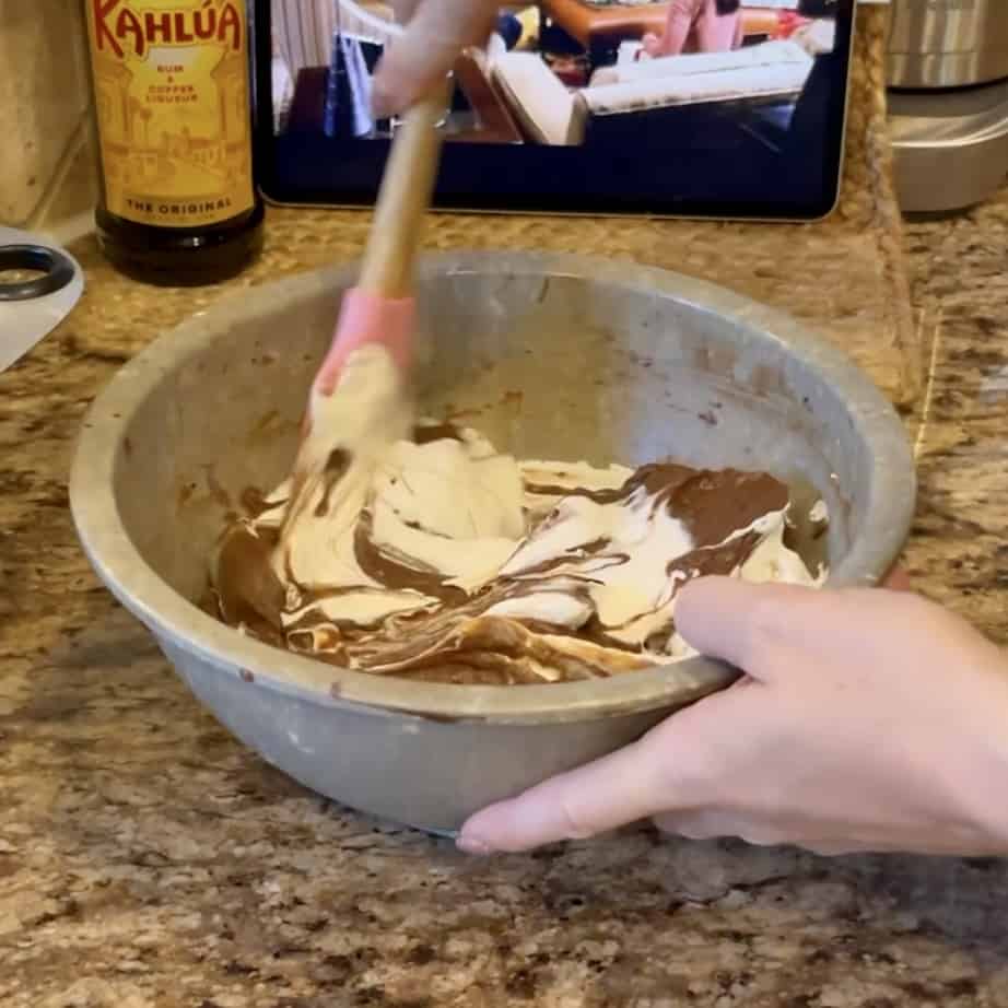 Mixing together chocolate pudding and whipped cream for a trifle.