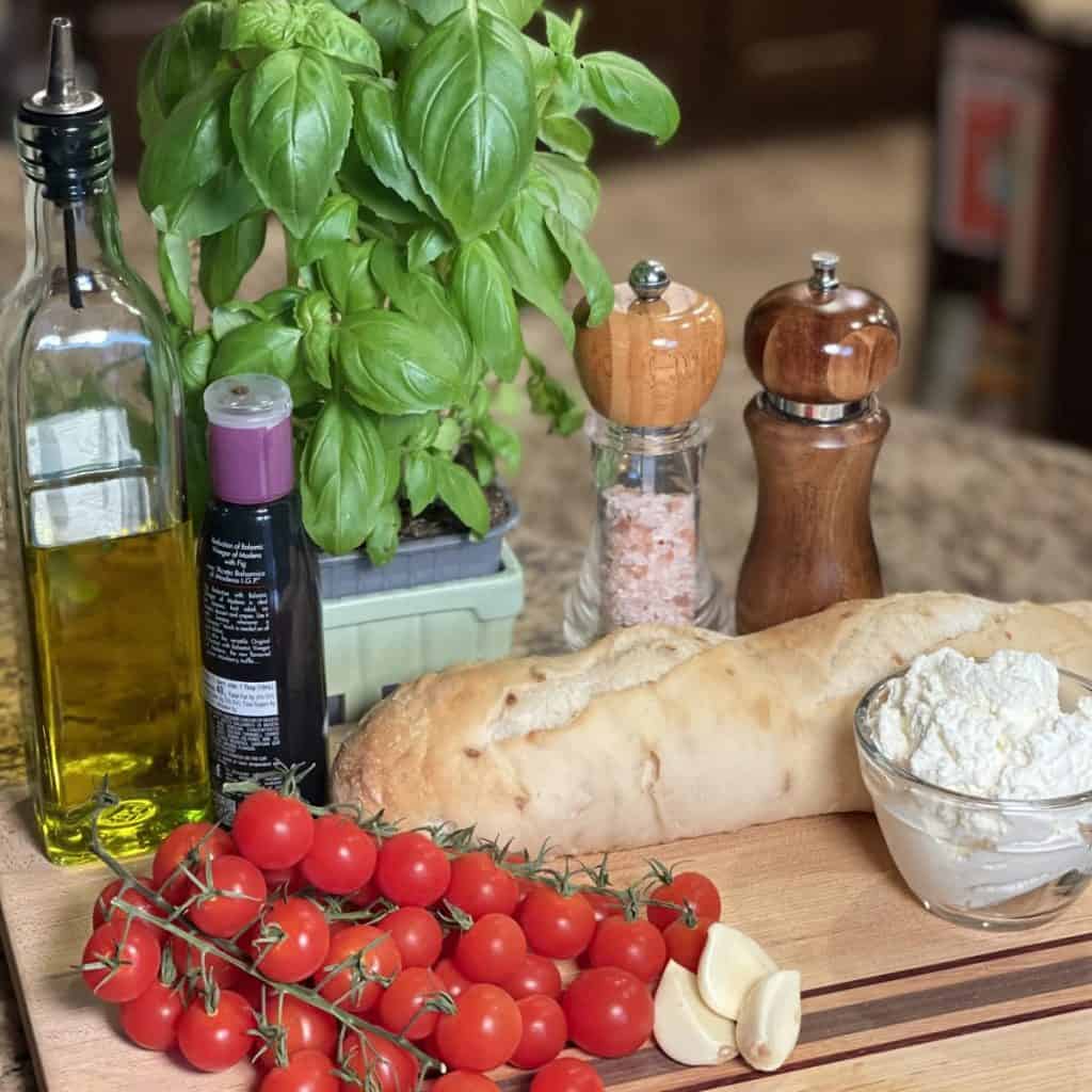 Ingredients to make roasted tomato basil ricotta toasts.