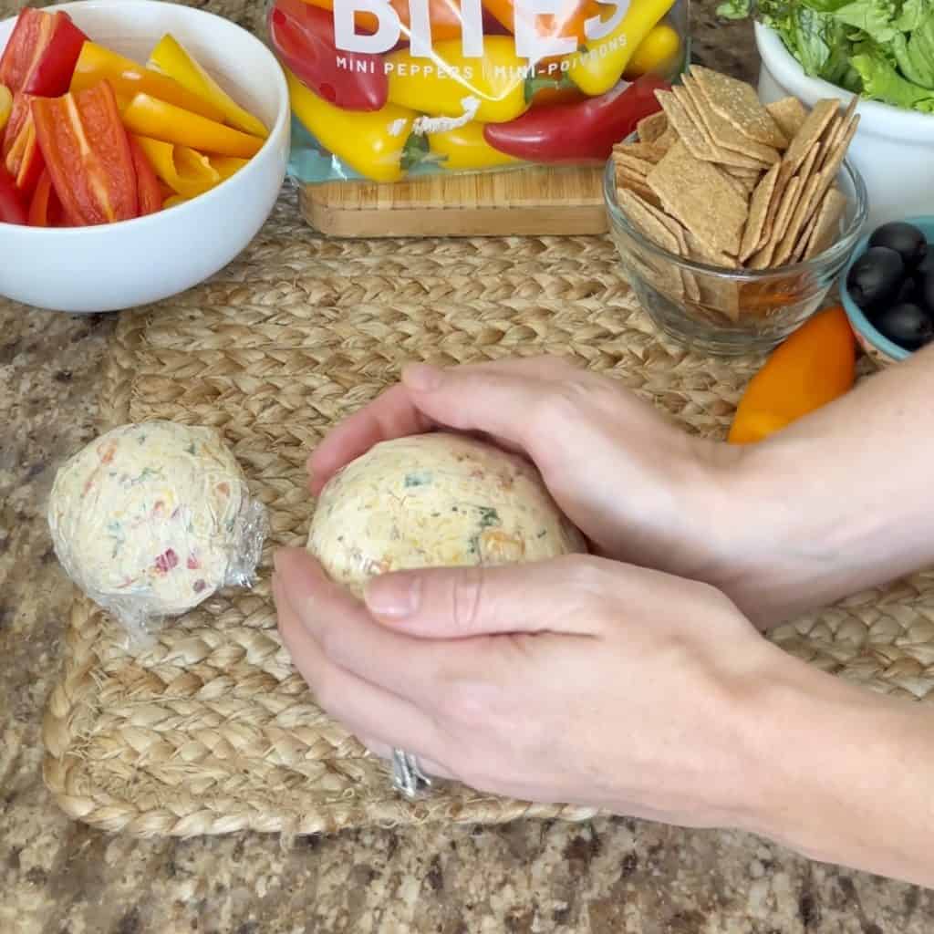 Shaping a cheeseball into balls.