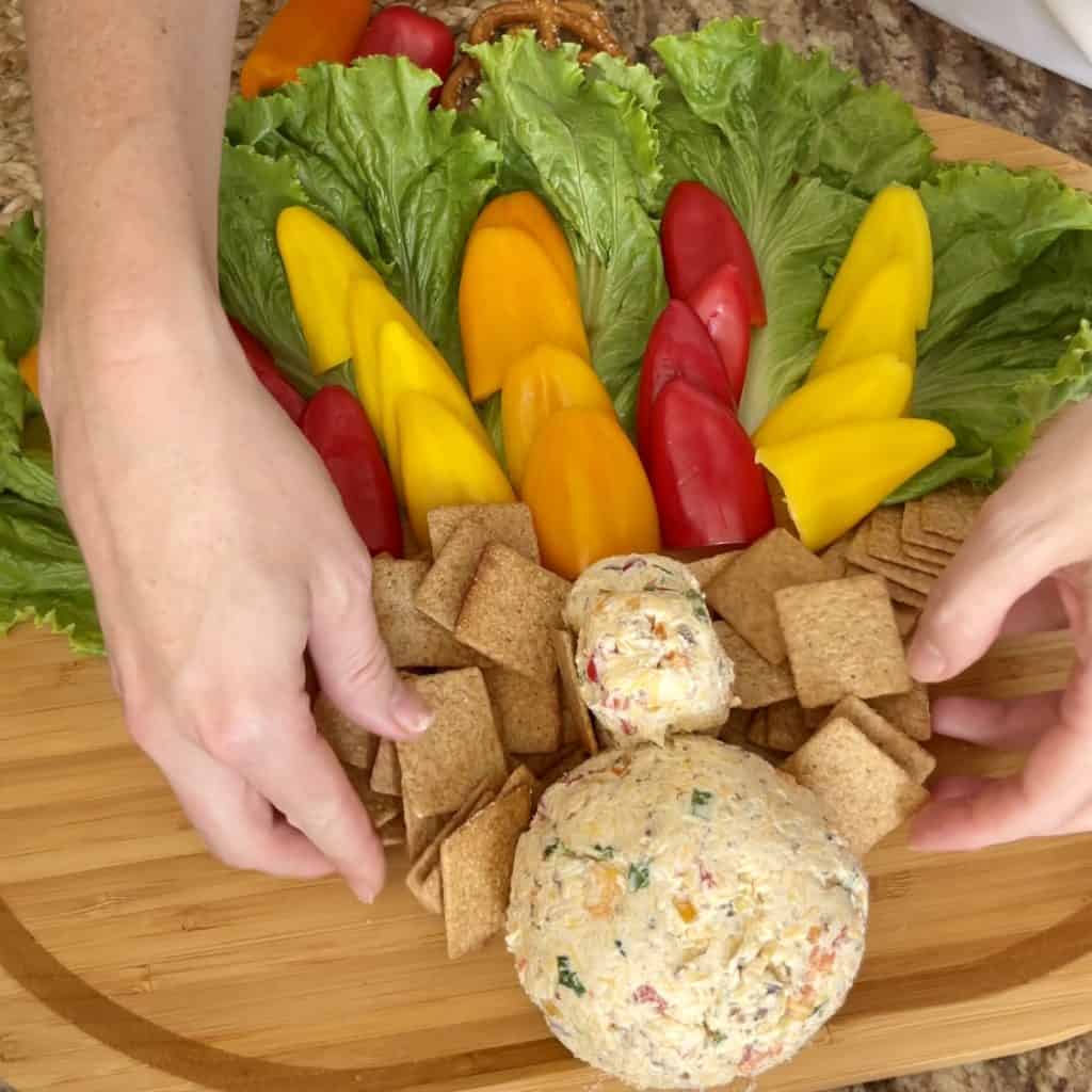 Adding crackers on a Cheeseball board.