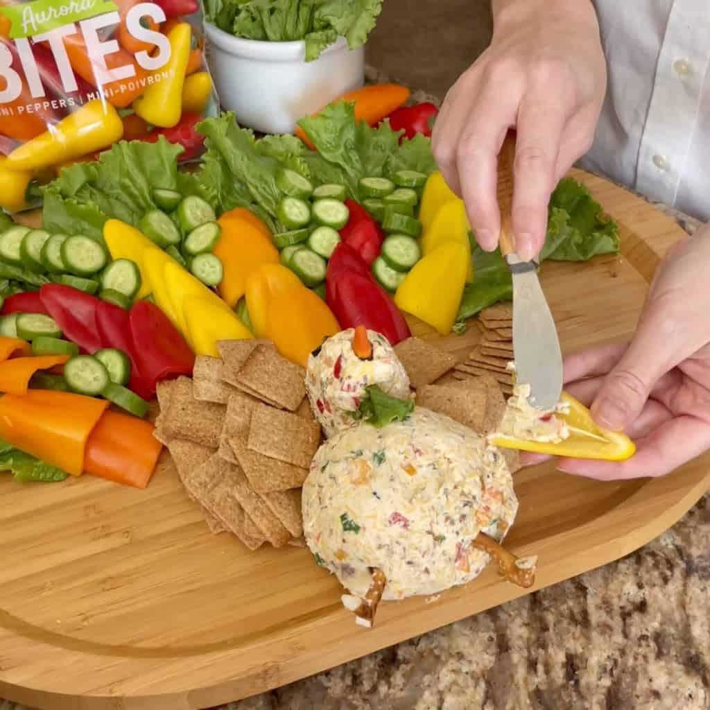 Adding turkey cheeseball spread on a a pepper.