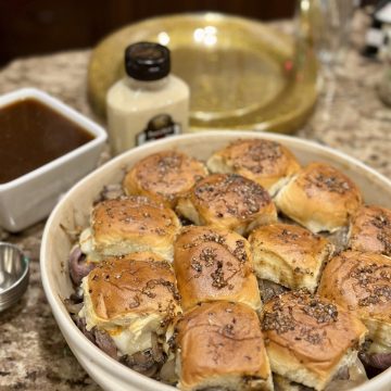 A serving dish of French dip sliders.