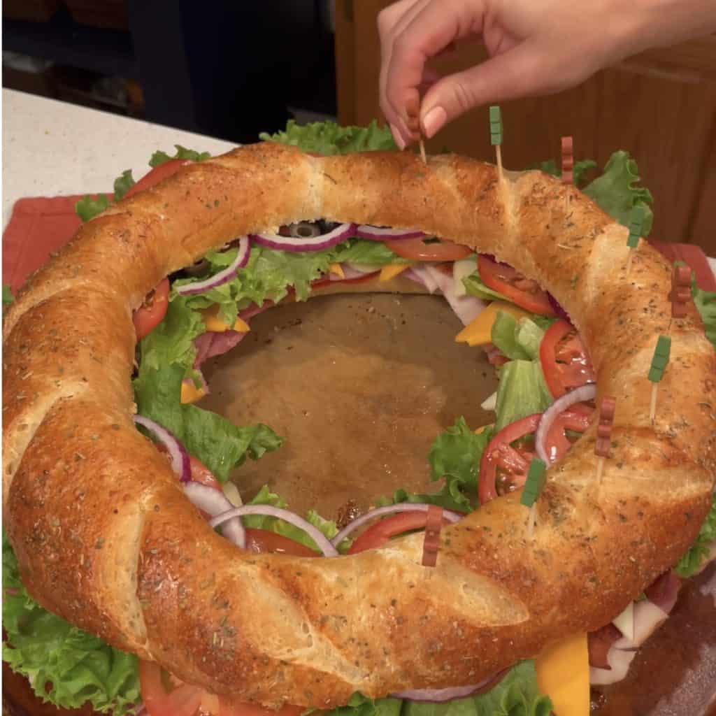 Adding party picks to a sub sandwich.