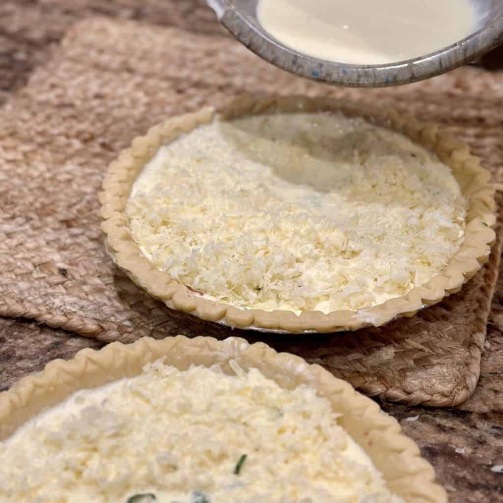 Pouring an egg mixture to the top of quiche crust.