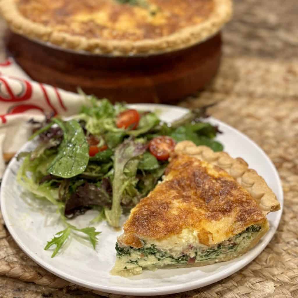 A plate of salad and quiche.