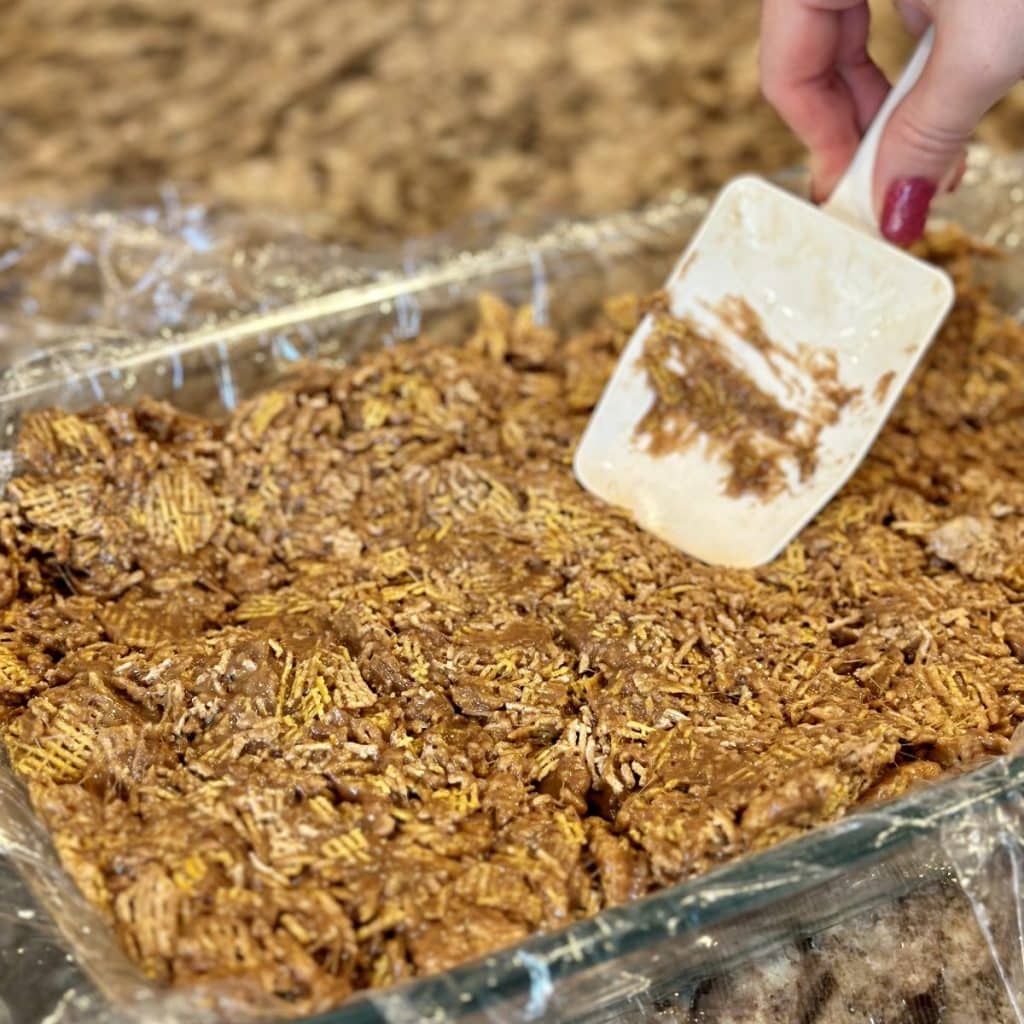 Pressing the treat bars in a 13x9 pan.