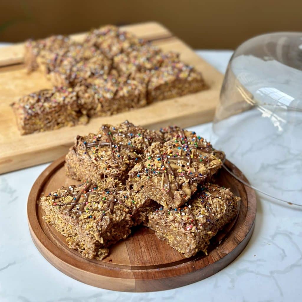 A plate stacked with peanut butter hazelnut crispix treats.