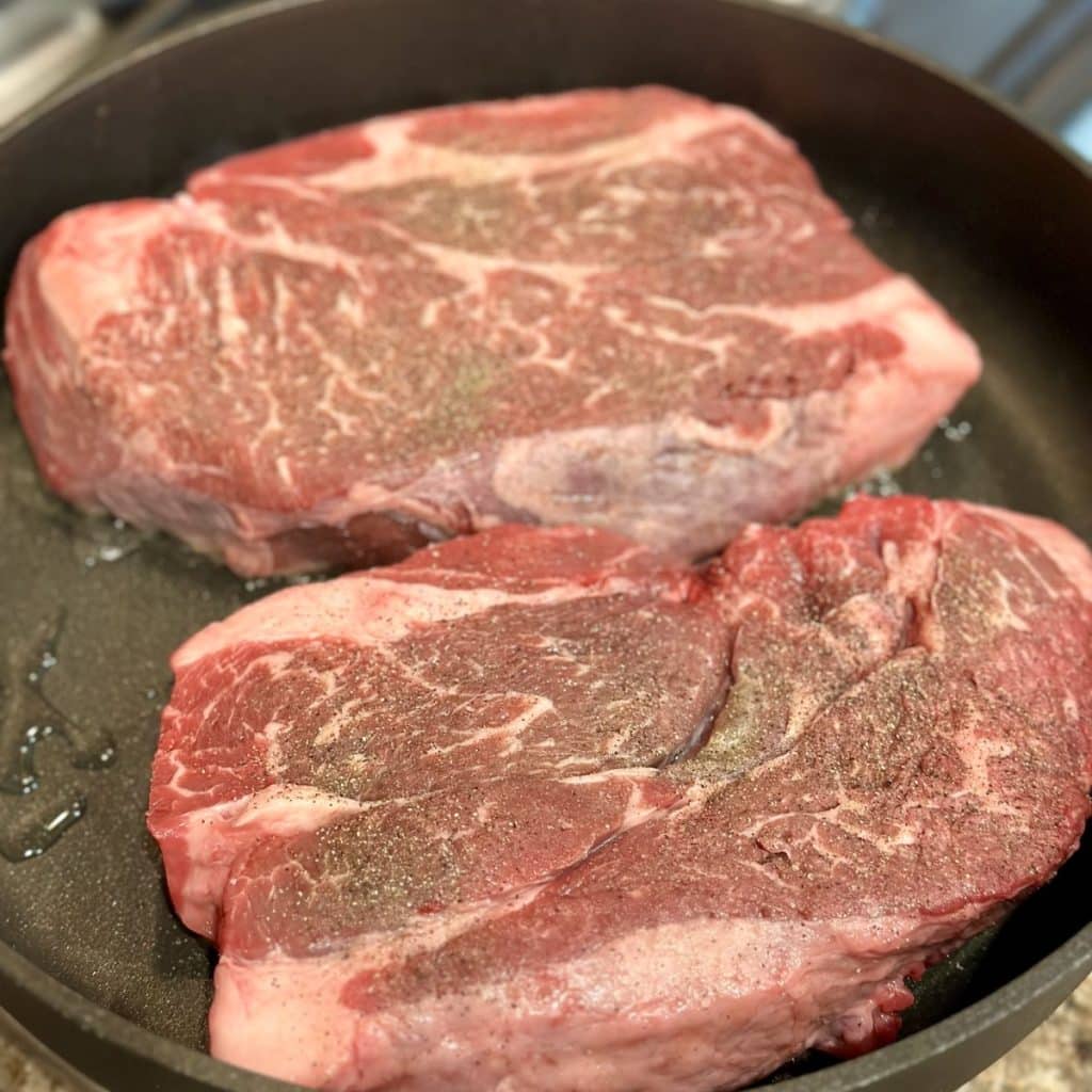 Roasts being seared in a skillet.