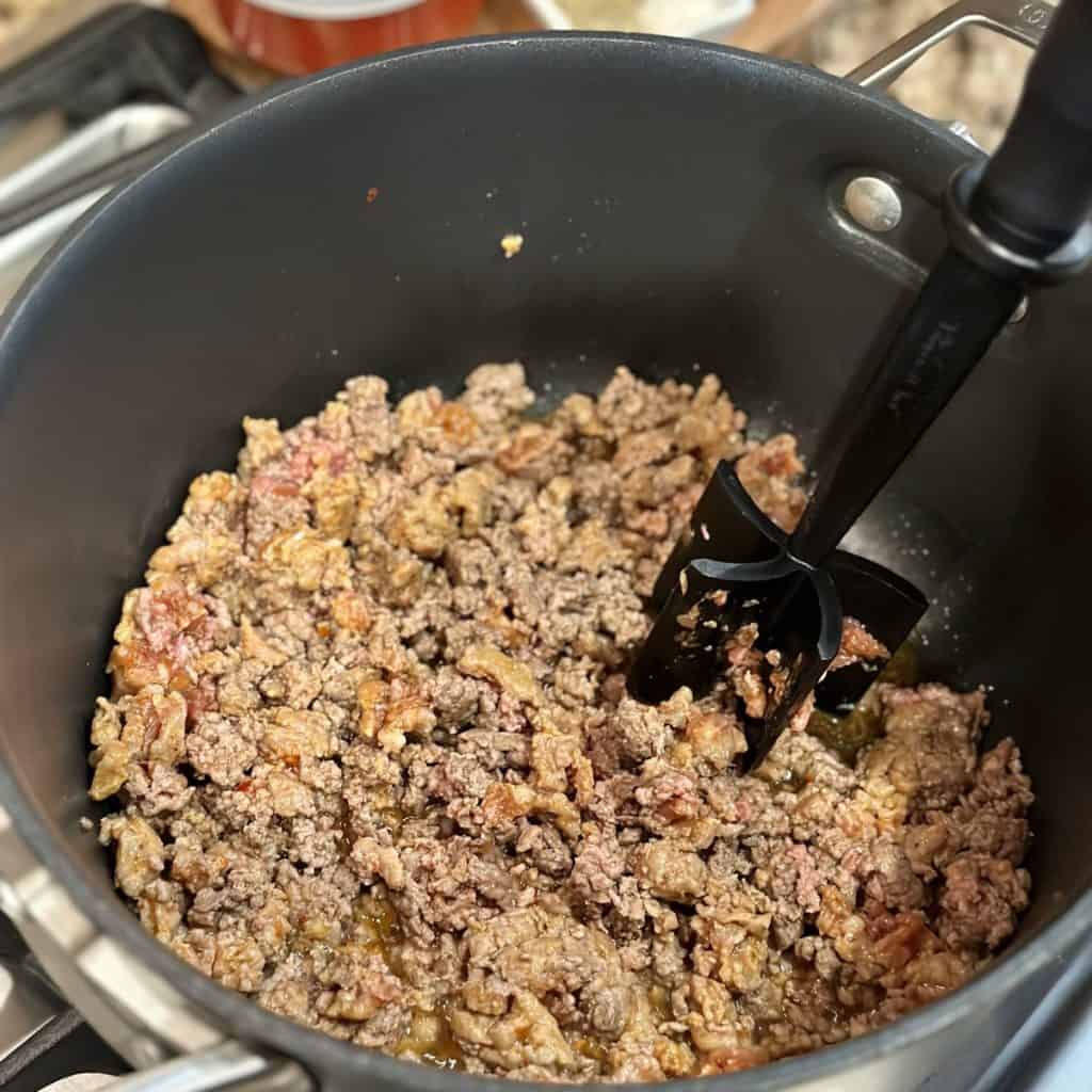 Browning ground beef and Italian sausage in a pot.