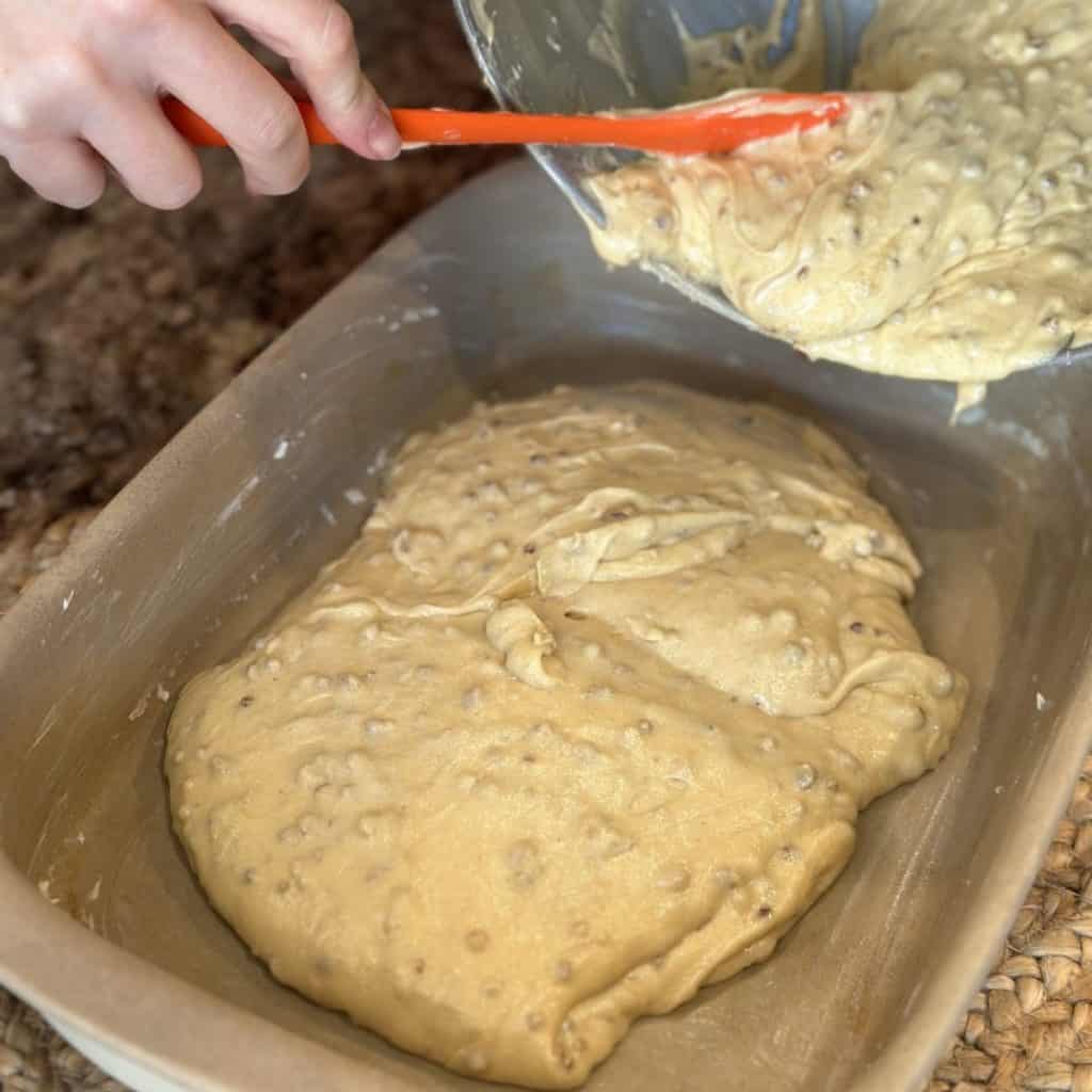 Pouring batter in a cake pan.