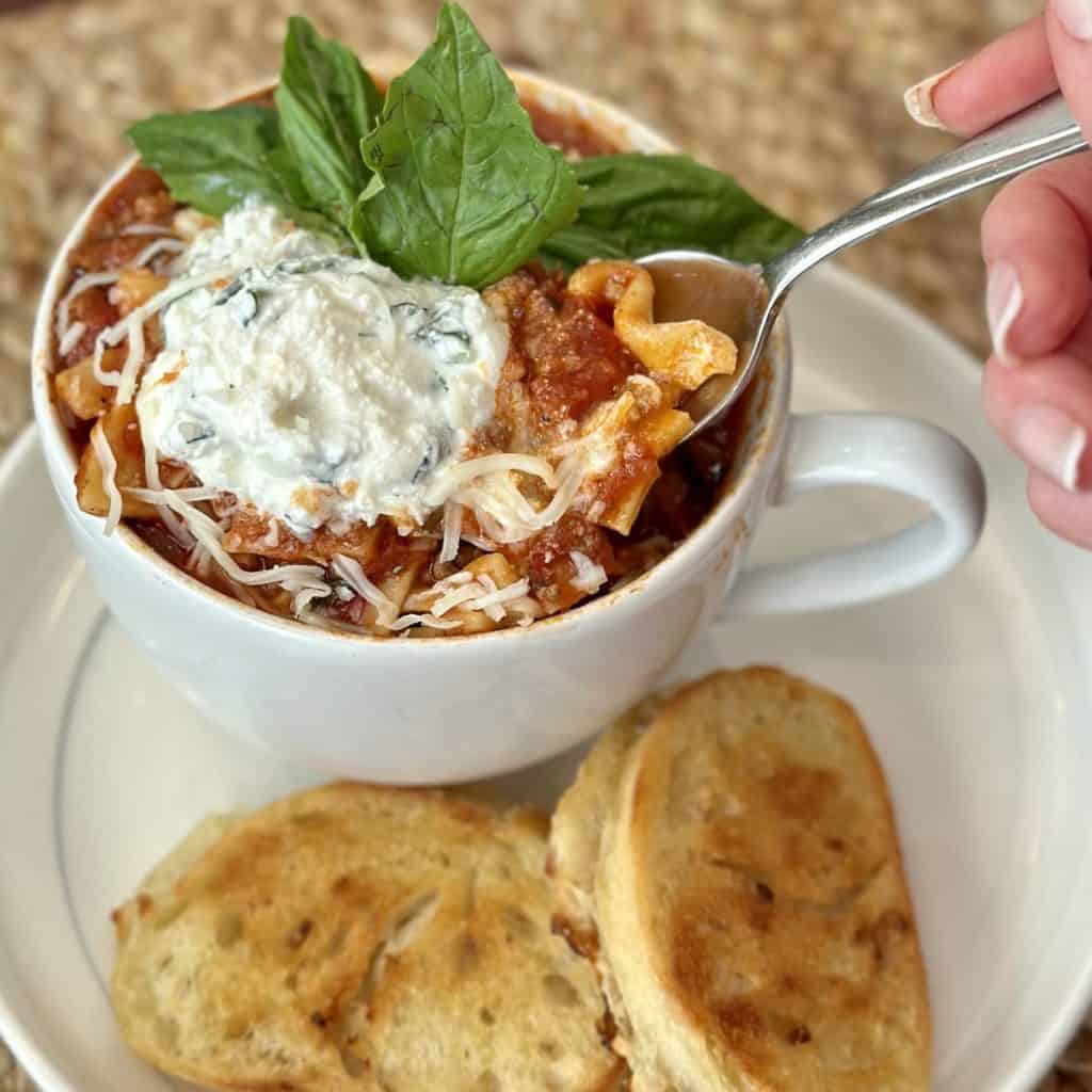 A bowl of lasagna soup and toasted cheese sandwich.