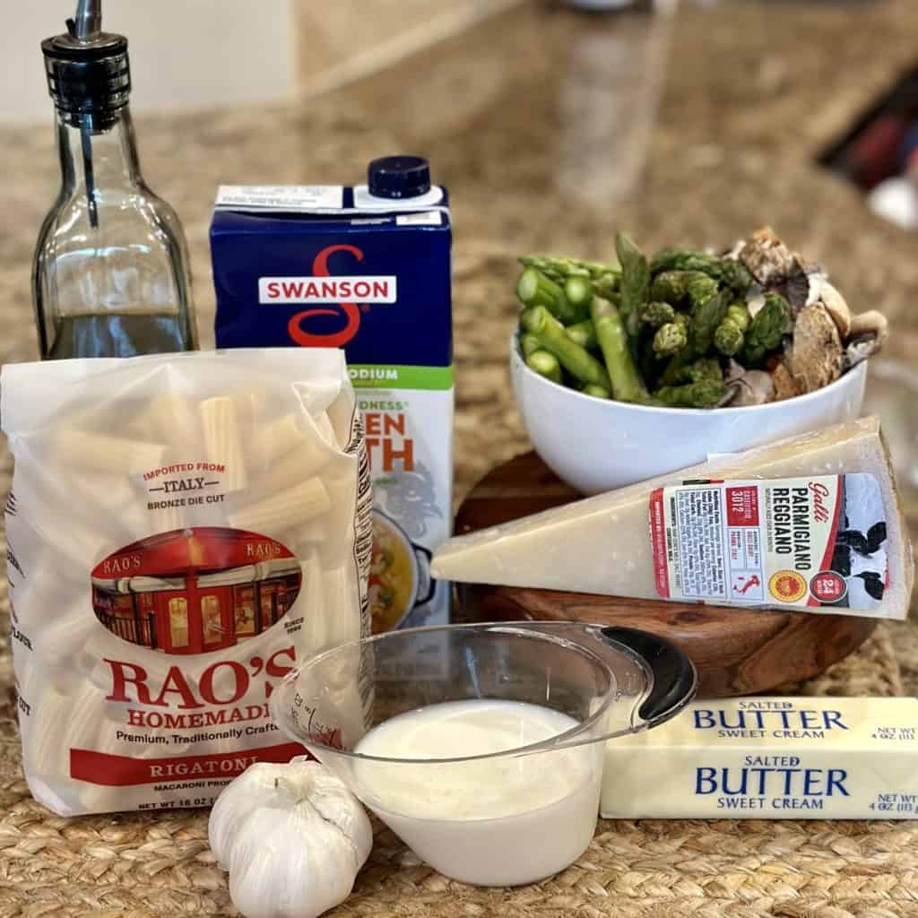 The ingredients to make a creamy parmesan asparagus mushroom pasta.