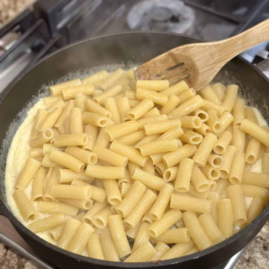 Stirring pasta in a pan.