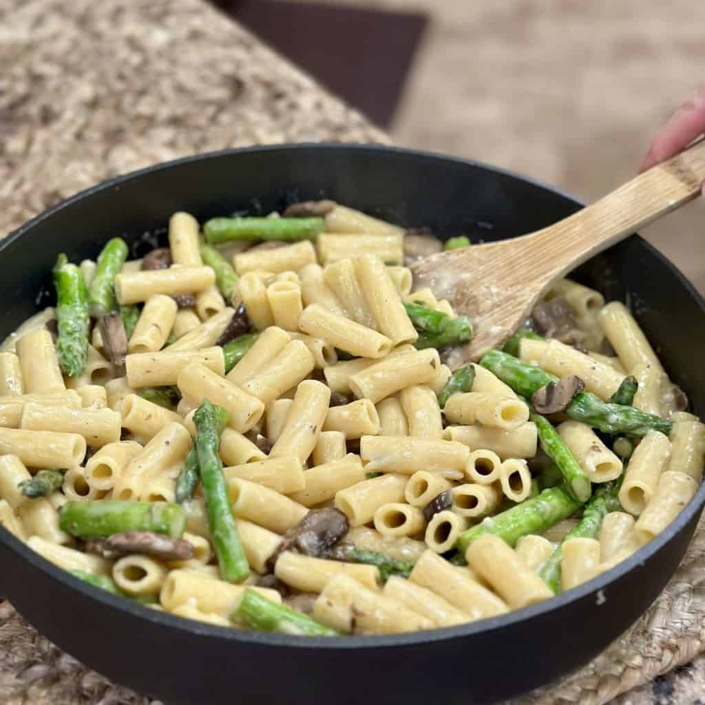 Stirring pasta in a pan.