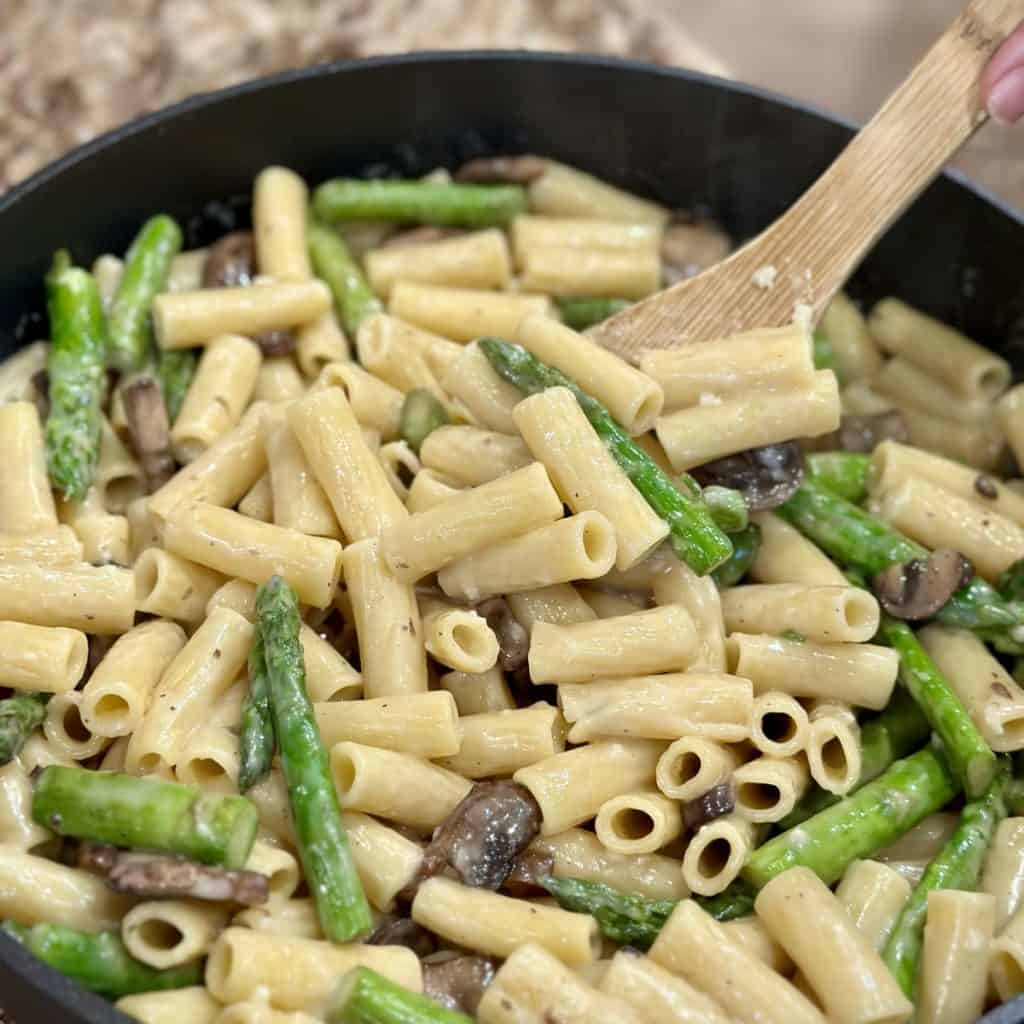 Stirring pasta in a skillet.