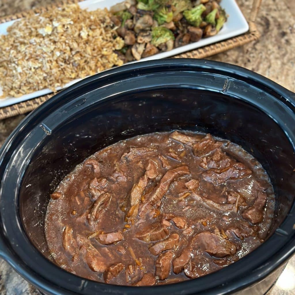 A completed cooked flank steak in a crockpot.