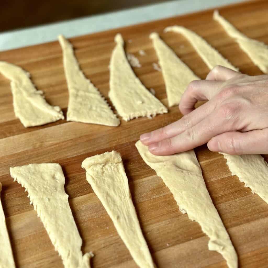 pressing flat crescent roll dough.
