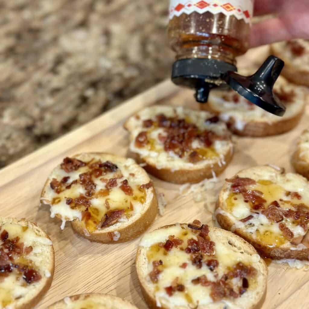 Adding honey to the top of bacon and cheese bread.