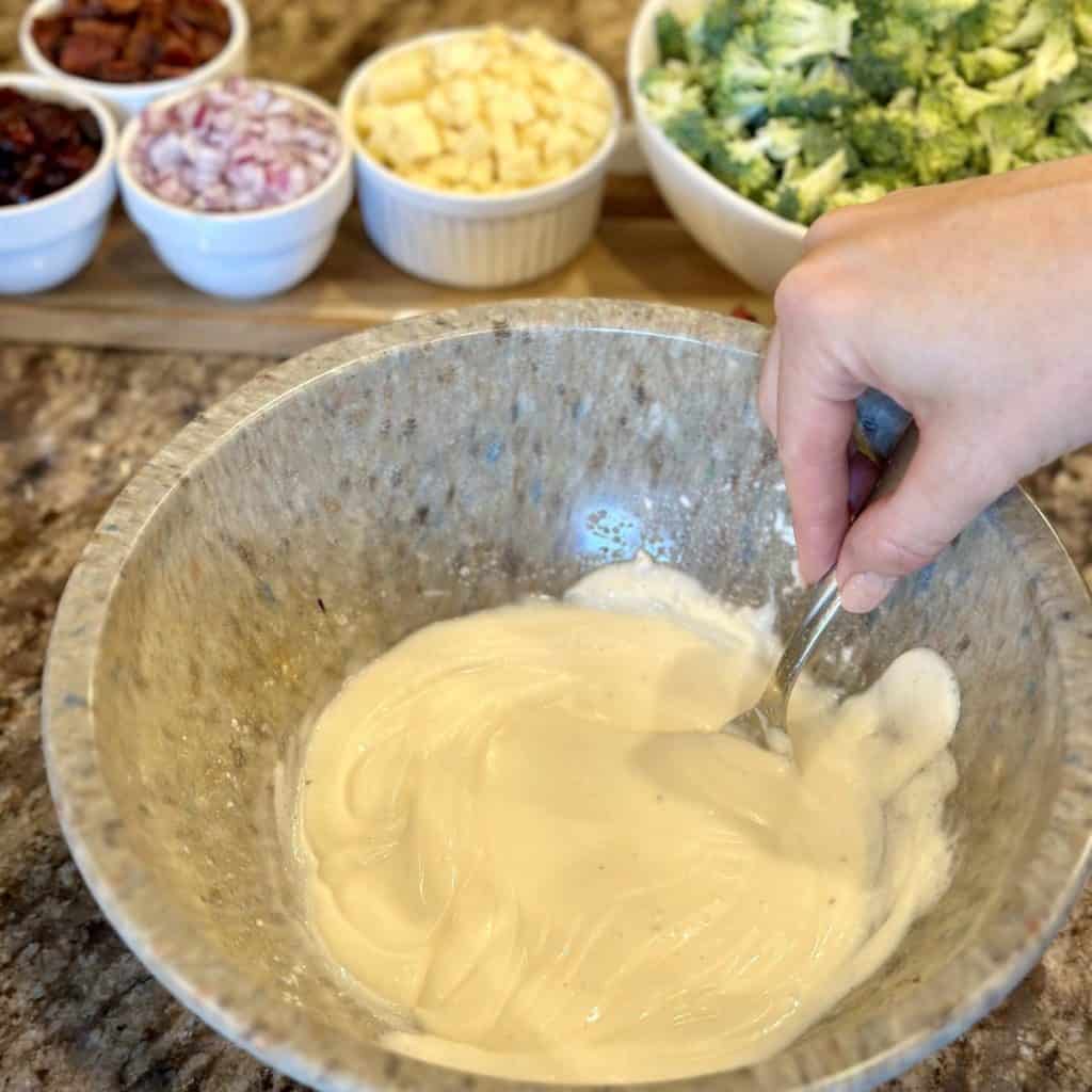 Mixing together dressing for broccoli salad.