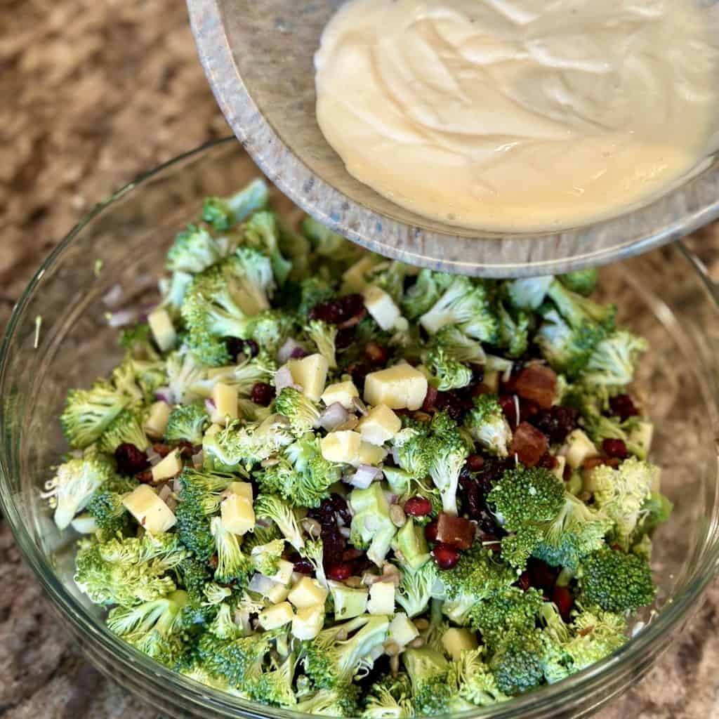 Pouring dressing on broccoli salad.