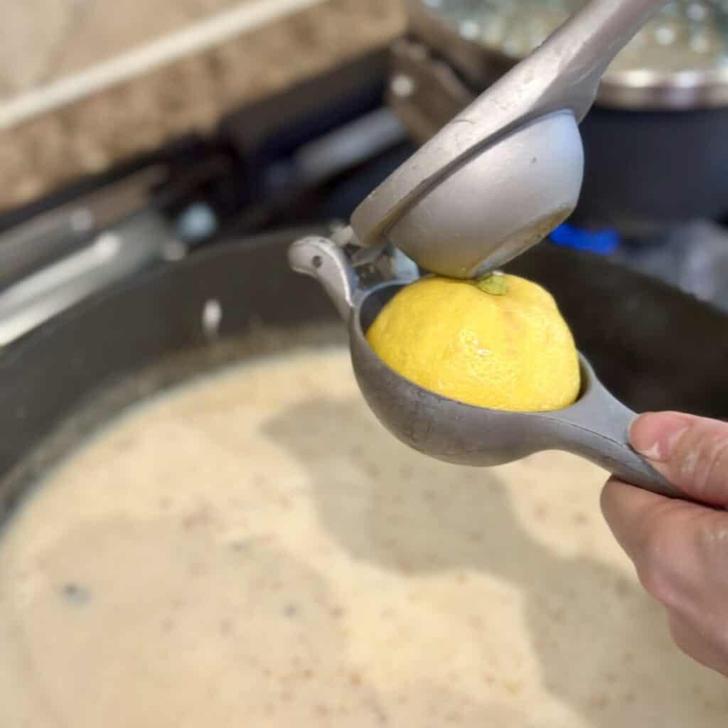 Adding lemon juice to gravy in a skillet.
