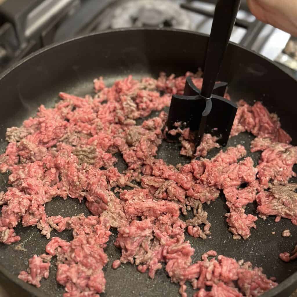 Browning ground beef in a skillet.