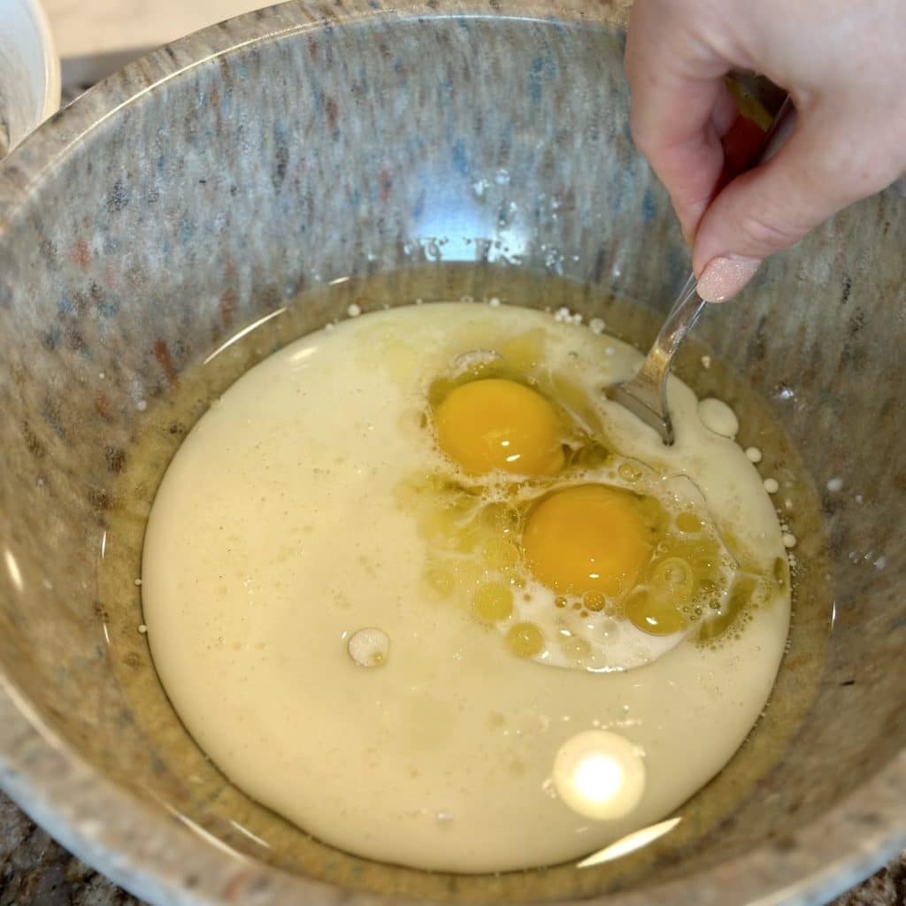 Whisking together eggs, oil and sugar in a boil.