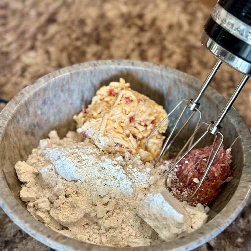 Mixing ingredients for sausage balls in a bowl.