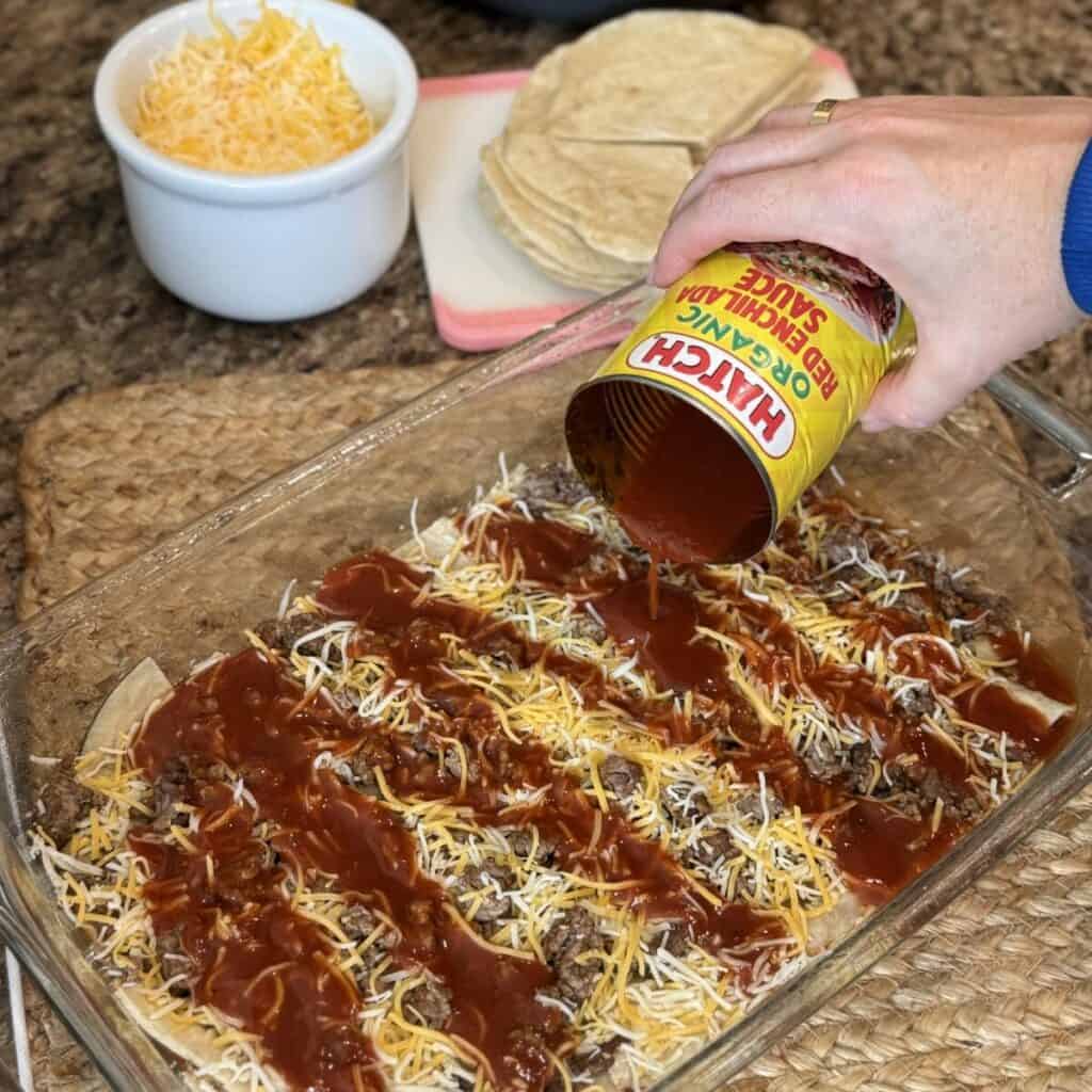 Adding the layers for taco lasagna in a baking dish.