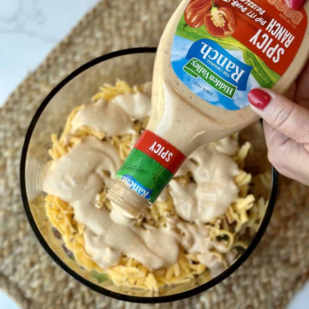 Adding spicy ranch dressing to cornbread chicken salad.