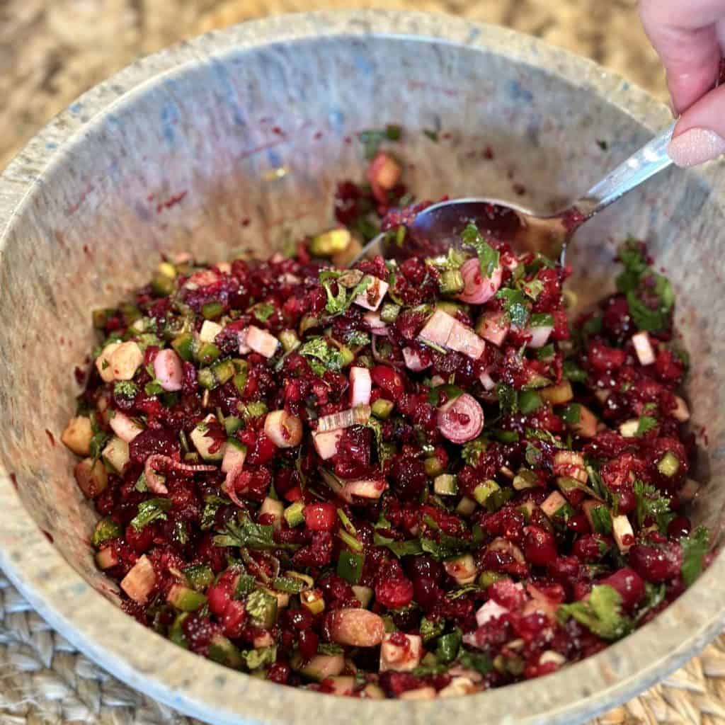 Mixing together the ingredients for jalapeno cranberry salsa.