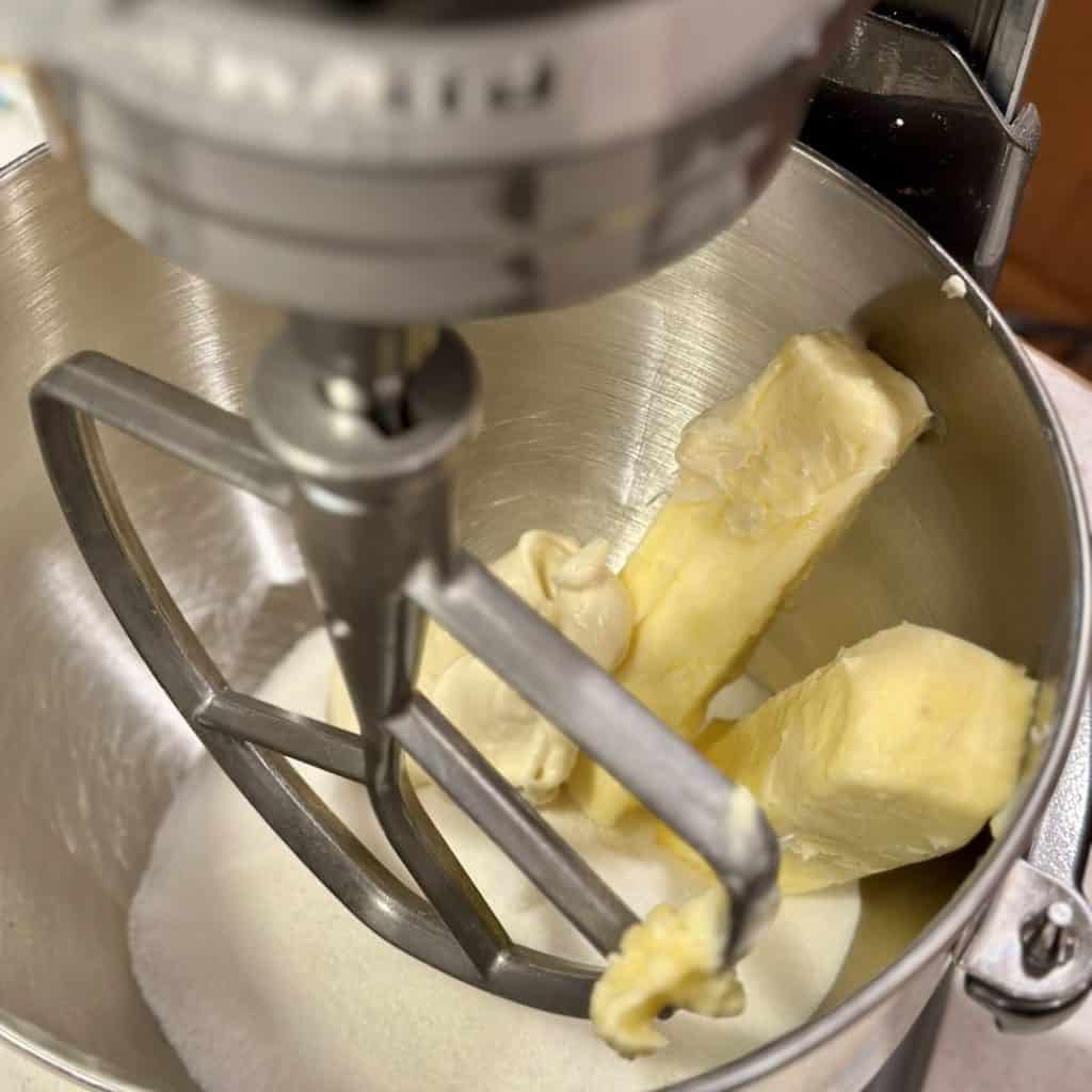 Mixing butter with sugar in a mixer.