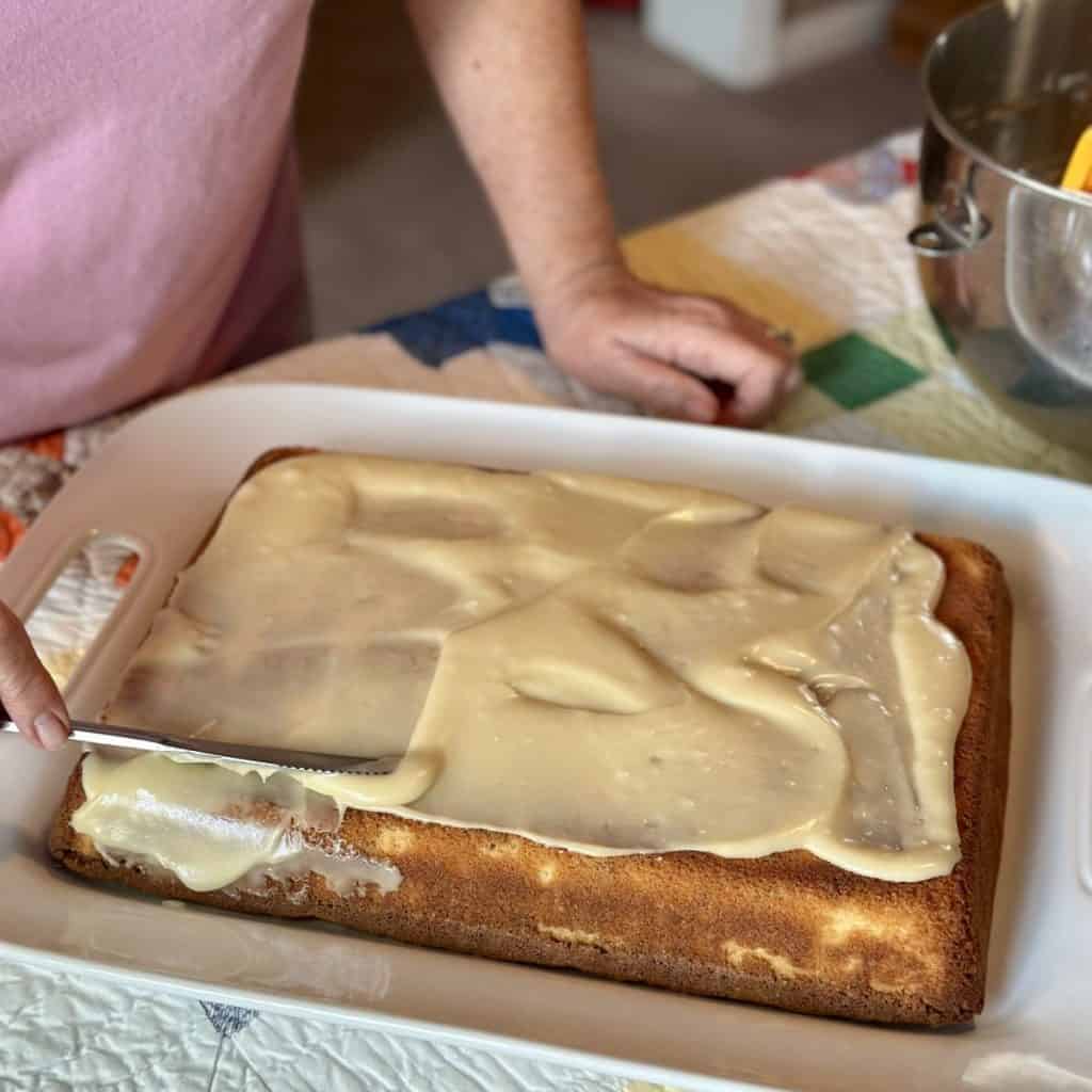 Spreading icing on a white chocolate cake.